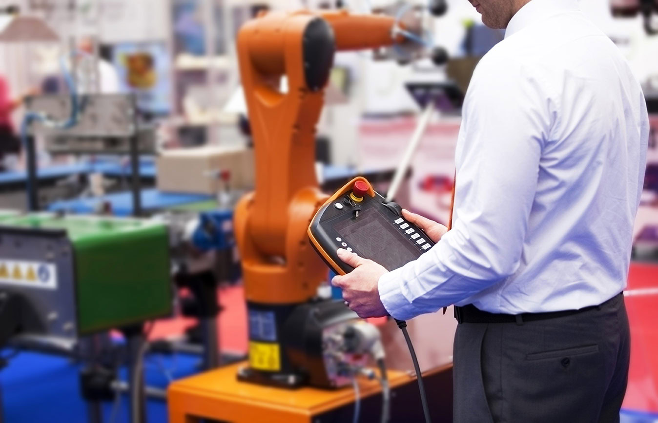 Engineer die een robot arm aan het testen is.