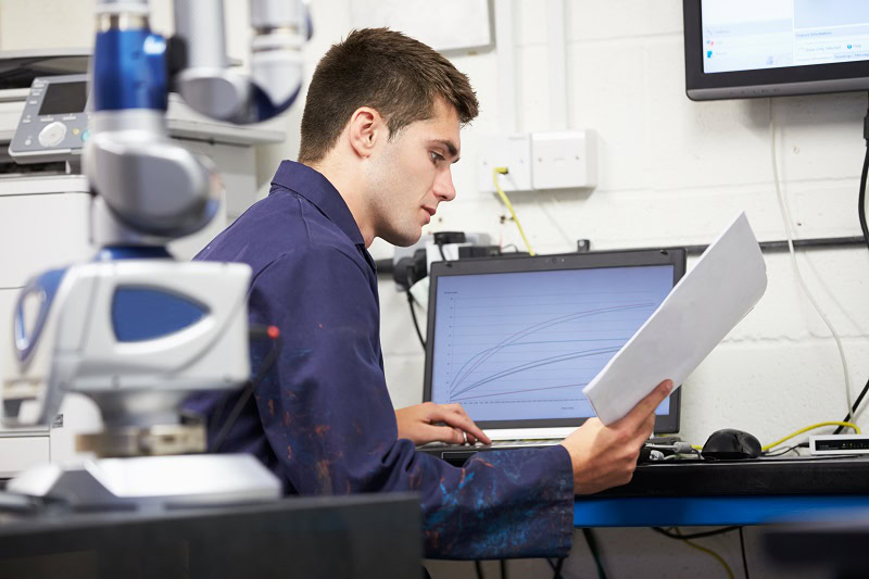 Engineer aan het werk op locatie, achter de computer grafieken controleren